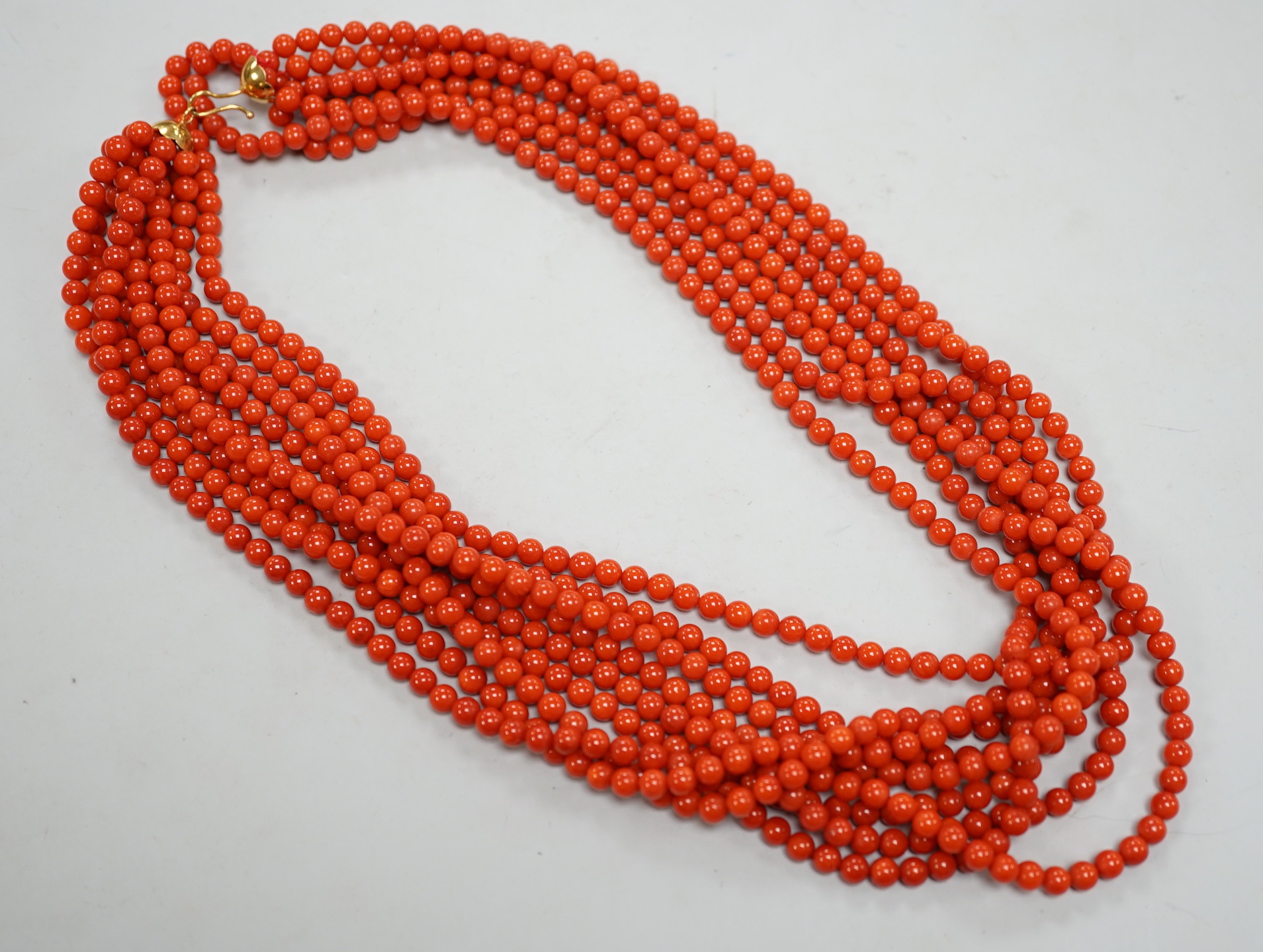 A 1980's Italian multi strand coral bead necklace, with 750 yellow metal clasp and Certificate of Authenticity, 50cm.